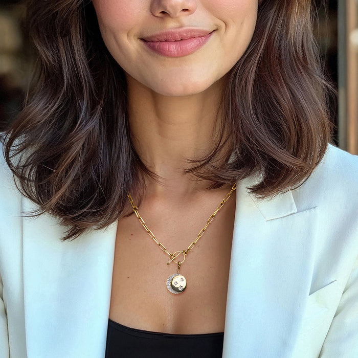 Model wearing a gold pearl necklace with a moon-and-stars charm pendant