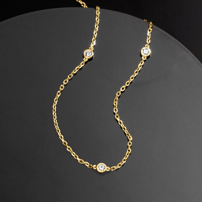 Gold station necklace with five round diamond stations on chain