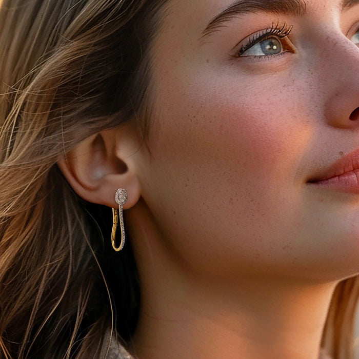 Gold hoop earrings with small diamond cluster at front, shown on wearer's ear