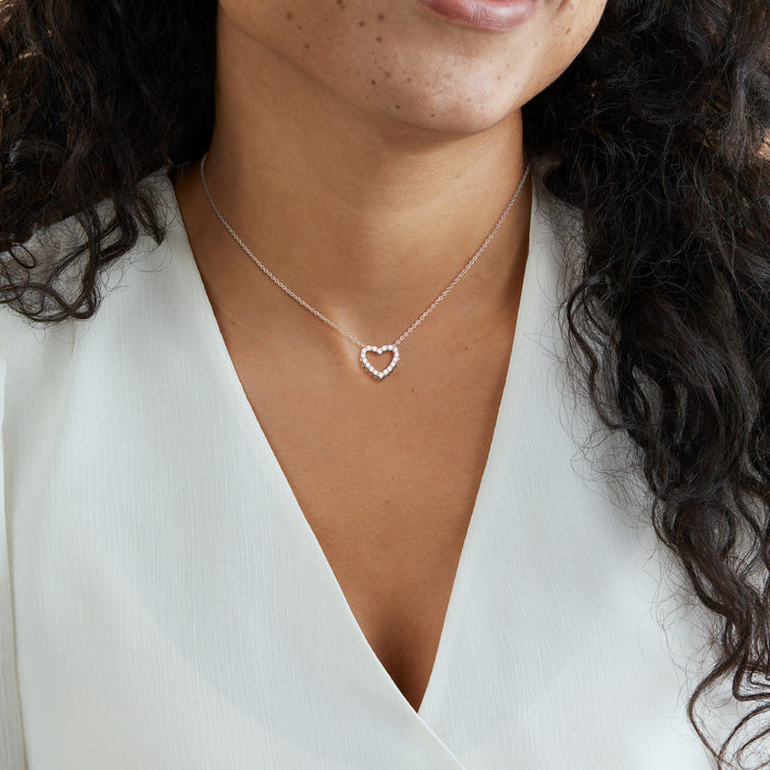 Sterling silver necklace with heart pendant, worn at neckline with small chain