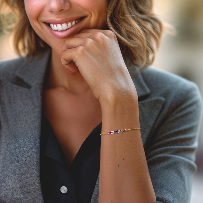 Bolo bracelet worn on wrist with thin gold chain and small multi-gem stones